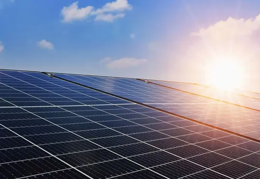 Eine Photovoltaik-Anlage und Sonnenschein bei blauem Himmel