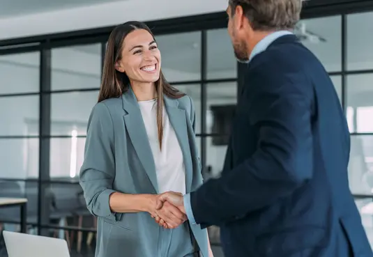 Händeschütteln einer Frau und eines Mannes in einem modernen Büro