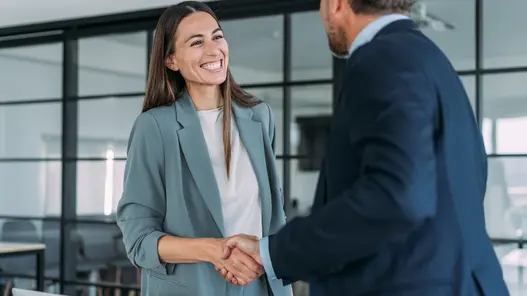 Händeschütteln einer Frau und eines Mannes in einem modernen Büro