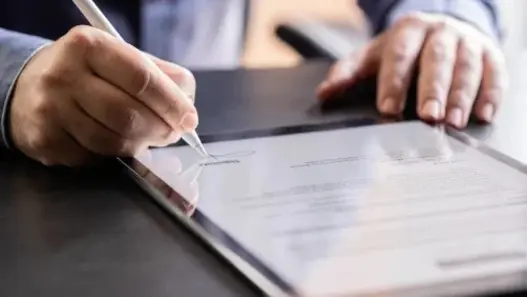 Mann unterzeichnet digitalen Vertrag auf einem Tablet