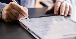 Mann unterzeichnet digitalen Vertrag auf einem Tablet