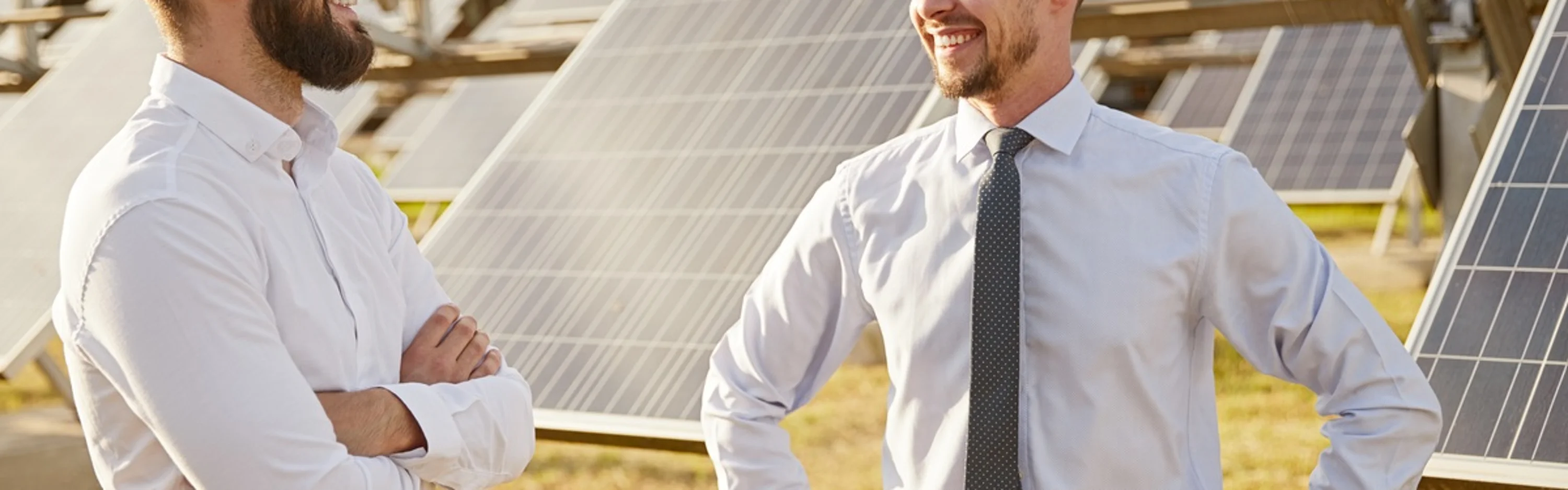 Zwei Business-Herren vor einer PV-Anlage.