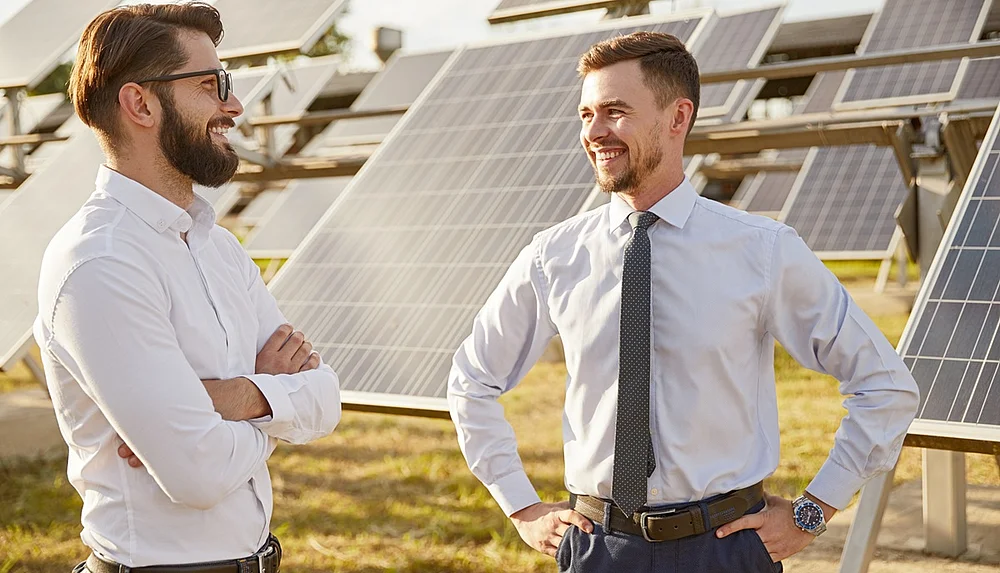 Zwei Business-Herren vor einer PV-Anlage.