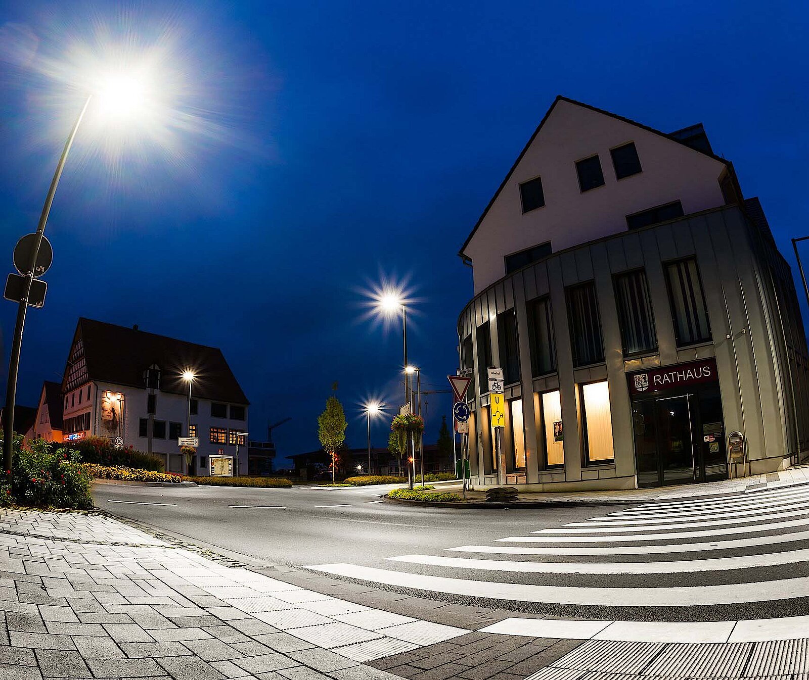 Straßenbeleuchtung vor einem Rathaus bei Nacht