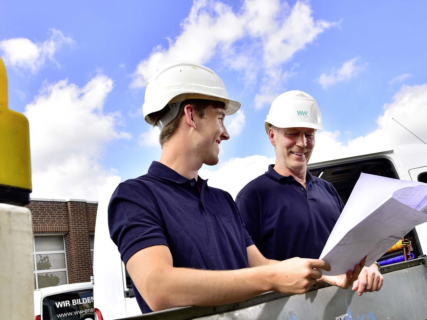 WWN Monteur Zwei Monteure mit Helm an einer Baustelle