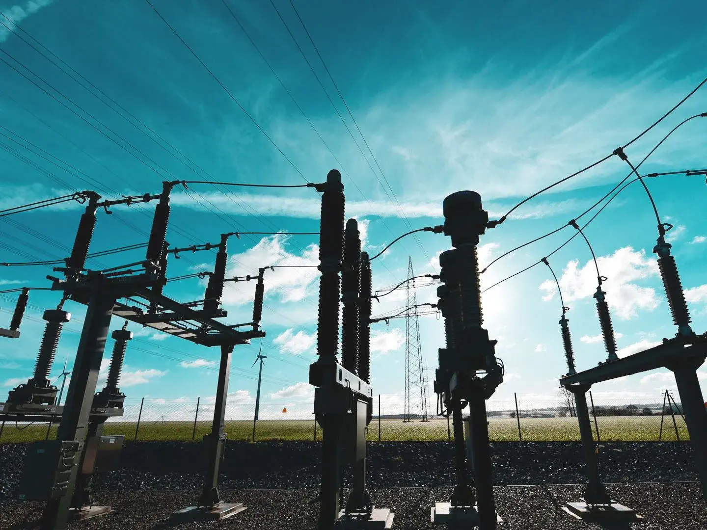 WW ntelligente Netztechnik Umspannwerk mit Strommast und Windrädern im Hintergrund