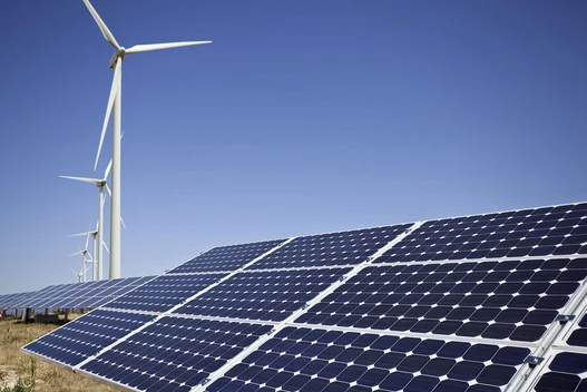 Solar-Panel mit Windrädern im Hintergrund