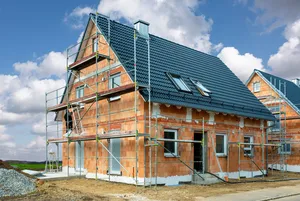 Neubau eines Einfamilienhauses Einfamilienhaus im Rohbau mit Ziegeldach und Baugerüst